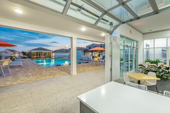 a patio with a pool and a table and chairs